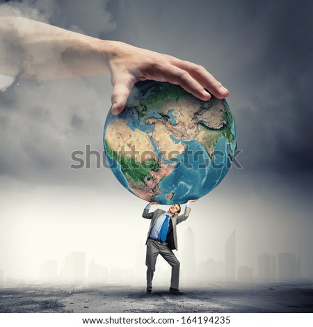 Image of young businessman under pressure of planet Earth. Elements of this image are furnished by NASA