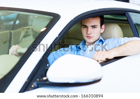 Image of young handsome guy sitting in car