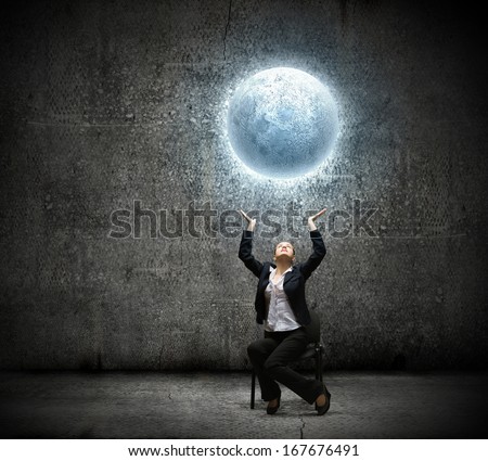 image of businesswoman holding moon in hands above head