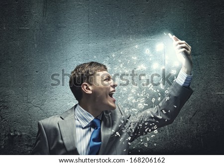 Angry businessman screaming i to mobile furiously phone