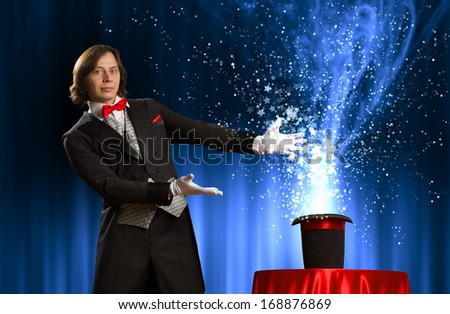 Image of magician holding hat with lights and fumes going out