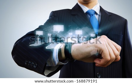 Businessman looking at wristwatch. Media technologies and innovations
