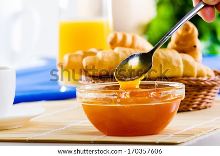 Croissants jelly and cup of coffee on breakfast table