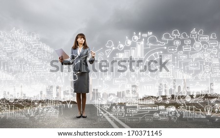 Businesswoman drawing business plan standing on road
