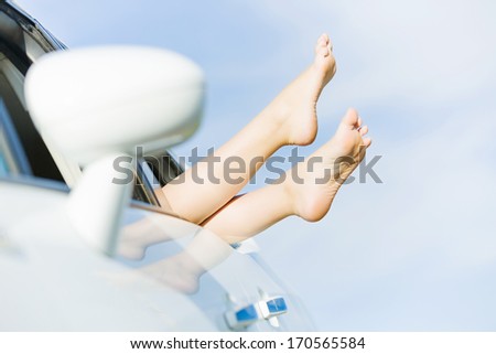 Feet of woman leaned out of car window