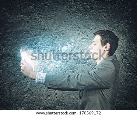 Young businessman looking seriously in tablet pc