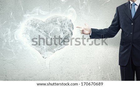 Businessman holding stone in shape of heart in palm
