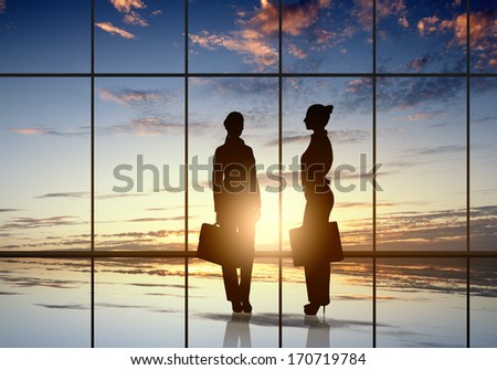 Silhouette of businesswoman against panoramic office window