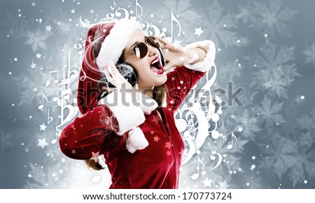 Young attractive Santa girl listening music in headphones