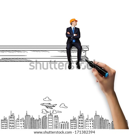 Businessman in helmet sitting on construction beam