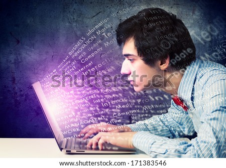 Image of young businessman at work using laptop