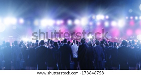 Crowd of businesspeople standing with back with lights at background