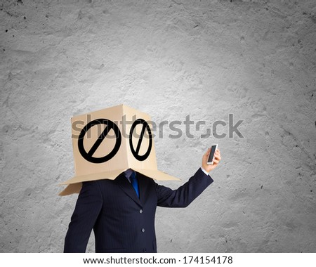 Troubled businessman with carton box on head expressing emotions