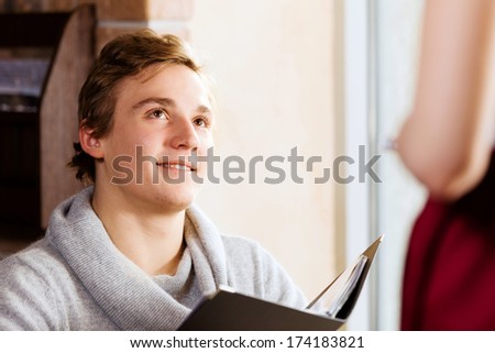 Young attractive woman making order at restaurant