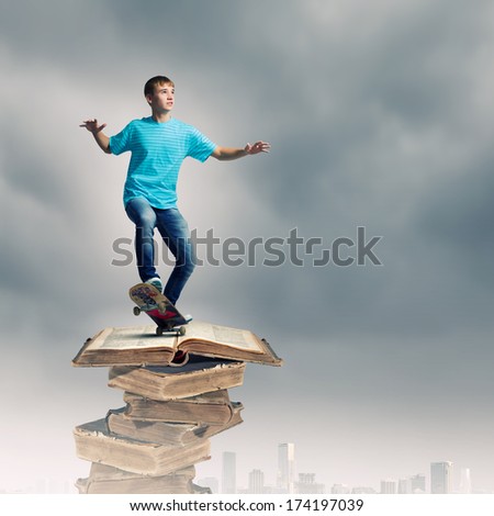 Boy skater standing on pile of old books