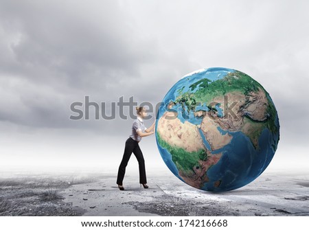 Young businesswoman pushing Earth planet. Elements of this image are furnished by NASA