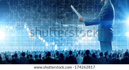 Back view of businessman speaker standing on podium with papers in hand