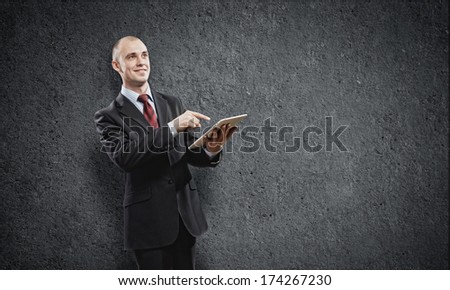 Handsome elegant businessman holding tablet pc in hands