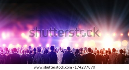 Crowd of businesspeople standing with back with lights at background