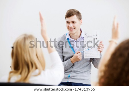 Young teacher in classroom standing in front of class