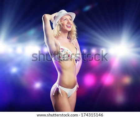 Attractive girl in swim wear dancing in party lights