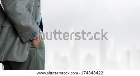 Bottom view of confident businessman with hands in pockets