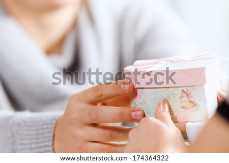 Close up image of hands presenting a box with surprise