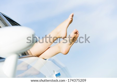 Feet of woman leaned out of car window