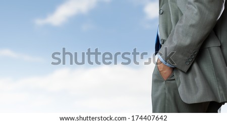 Bottom view of confident businessman with hands in pockets