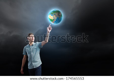 Young man against dark background and Earth planet image. Elements of this image are furnished by NASA