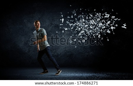 Funny image of young man trying to escape from flying letters