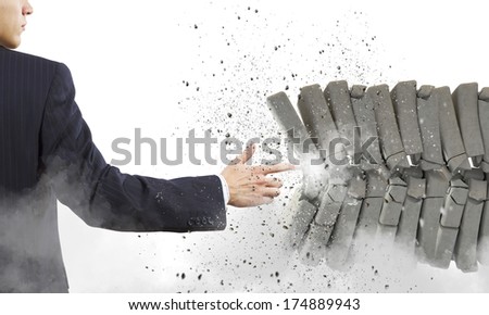 Businessman crushing pile of stones with finger touch