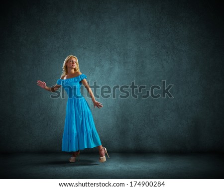 Anxious young woman in blue dress looking back worried