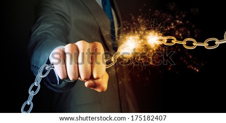 Powerful businessman holding chain in his fist
