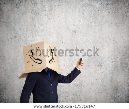 Troubled businessman with carton box on head expressing emotions