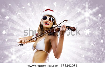 Young Santa girl in bikini playing violin