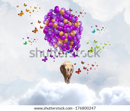 Sunny image of elephant flying in sky on aerostat