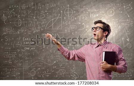 Young funny man in glasses against chalkboard with sketches