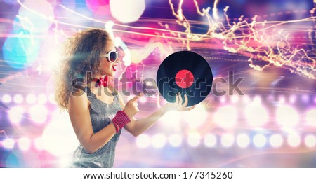 Young pretty girl dj at disco party holding vinyl