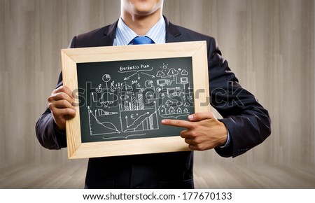 Close up of businessman holding frame with business sketch