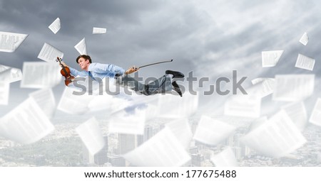 Young businessman flying in sky and playing fife