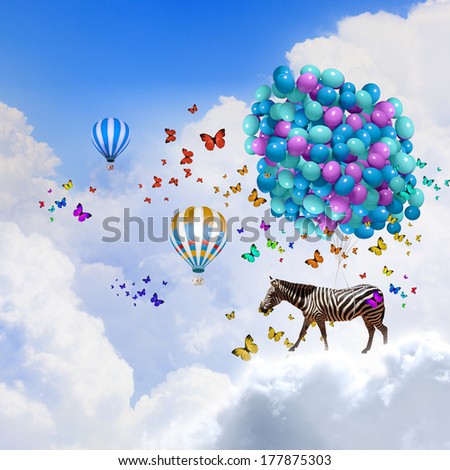 Fantasy image of zebra flying in sky on bunch of colorful balloons
