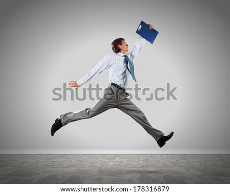 Young businessman in jump against blank background