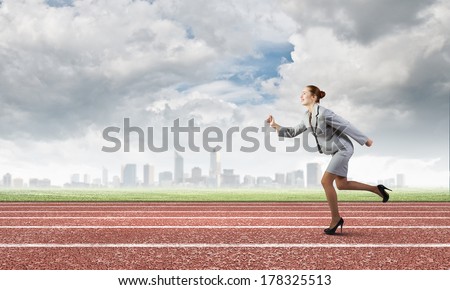 Young businesswoman in suit running on track