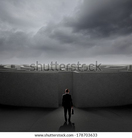 Successful businessman standing near the entrance of labyrinth