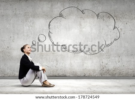 Young attractive lady sitting on floor of empty room
