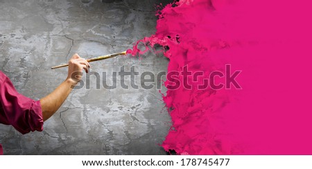 Young handsome man painter with brush in hand