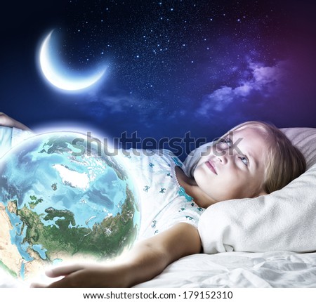 Girl in bed with Earth planet in hands.