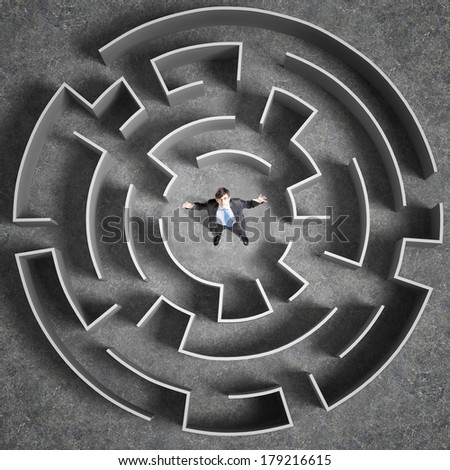 Top view of successful businessman standing in center of labyrinth
