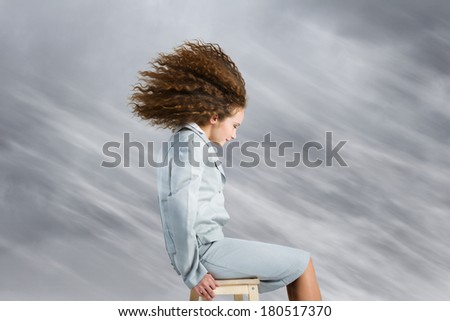 Young businesswoman with waving hair sitting on chair